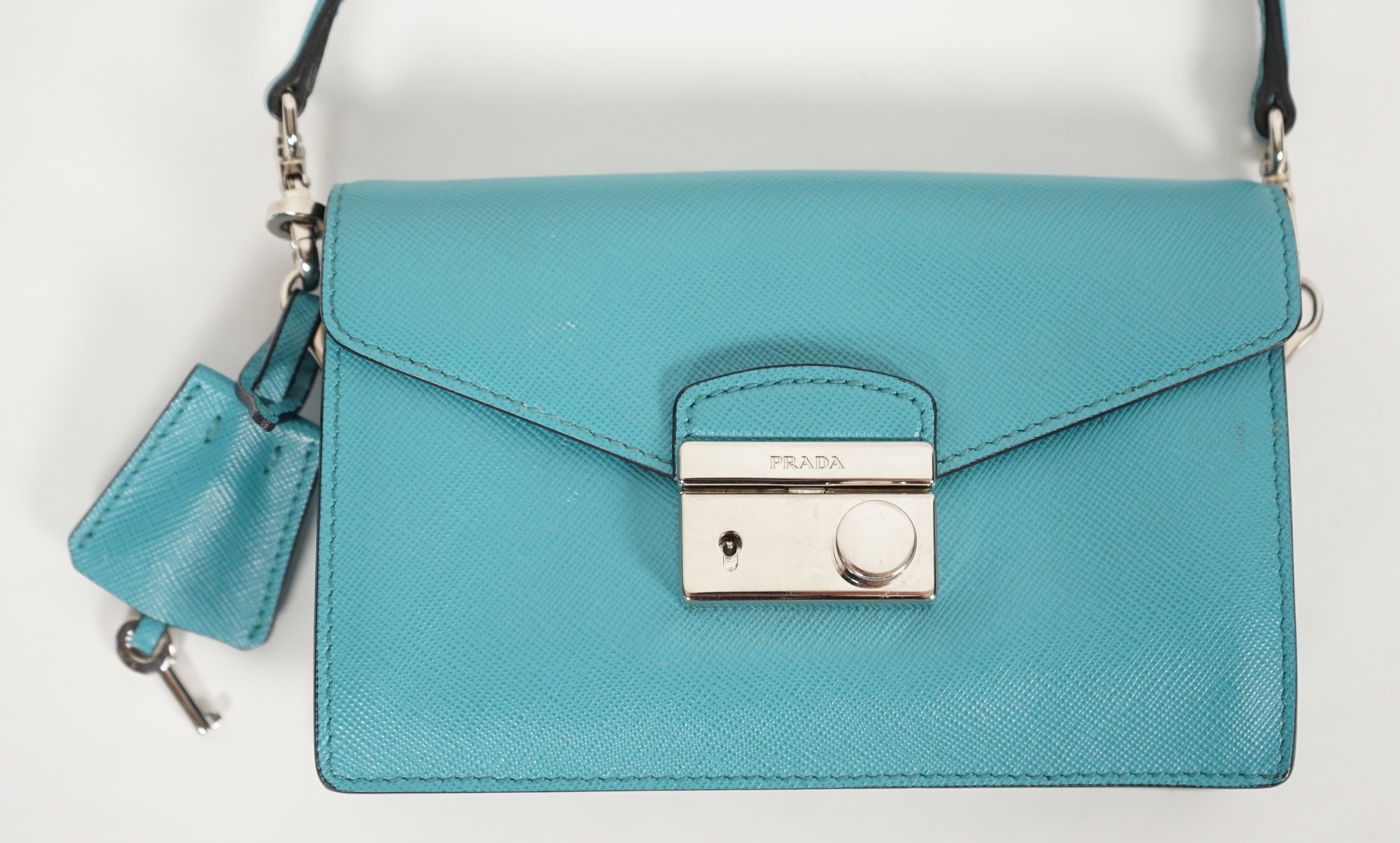 A Prada Saffiano Lux Mini Sound bag in Turchese, width 16cm, height 10cm, depth 4cm, overall height to handle 20cm